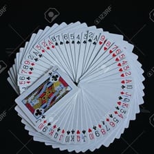 A pack of playing cards spread across a surface.