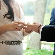 A newlywed couple exchanging wedding rings.