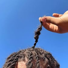 Close-up view of hair with visibly frizzy, unruly strands.