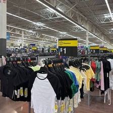 A retail clothing rack displaying merchandise marked for clearance.