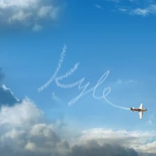 An airplane leaving a letter-shaped skywriting trail in the sky