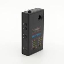 An electronic detector being used to locate a hidden microphone
