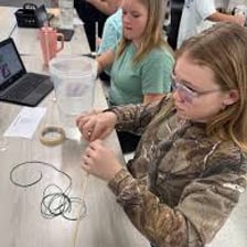 A teacher showing students how a machine operates