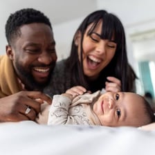 A newborn baby with parents experiencing parenthood for the first time.