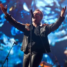 Bono performing with U2 on stage.