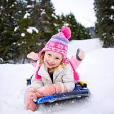 A sled positioned at the top of a snow-covered hill
