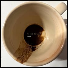 Sediment and a small amount of liquid left at the bottom of a cup.