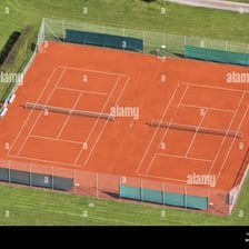 Outdoor tennis courts with marked playing lines and nets.