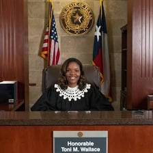 A judge presiding over proceedings in a courtroom.