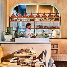 A cozy restaurant dining room with tables prepared for customers.