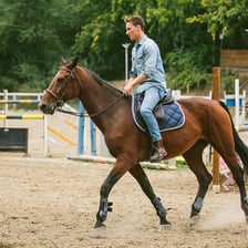 A person seated on and riding a horse