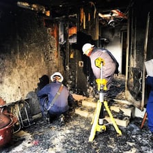 A fire investigator examining the remains of a burned building