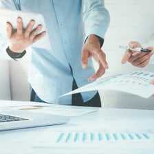 A person reviewing financial papers at a business meeting.