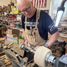 An expert craftsman carefully making a detailed object.