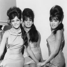 A woman wearing a tall, rounded beehive hairstyle