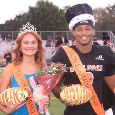High school students recognized as homecoming royalty at a ceremony.