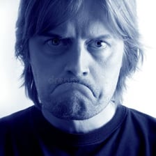 A person with a downcast expression and a frown.