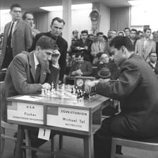 Bobby Fischer seated at a chessboard during a tournament.