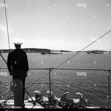 A sailor standing on the deck of a ship