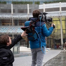 A television reporter delivering a live broadcast from outside a studio.