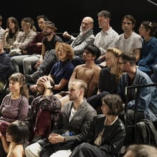 An audience member watching a stage performance with intense concentration.