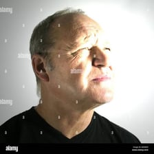 A person narrowing their eyes while facing bright sunlight