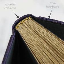 A bookbinder attaching covers and a spine to a book