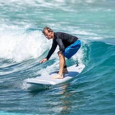 A surfer balancing on a surfboard while riding an ocean wave
