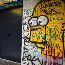 Graffiti covering and damaging the surface of a wall.