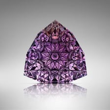 A gemstone showing a shallow concave recess cut into its surface.