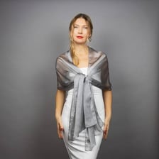 A person loosely wrapping a shawl around their shoulders