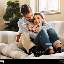 People cuddling together on a comfortable couch