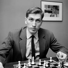 Bobby Fischer seated at a chessboard during a game