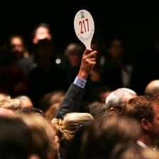 People raising bidding paddles during an auction.