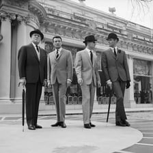 Several formally dressed men representing French gentlemen.