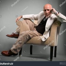 A person sitting in a loose, slouched posture in an armchair.