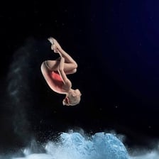 A gymnast rotating through the air during a somersault