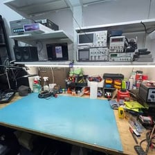 A person adjusting and rearranging parts on a workbench.