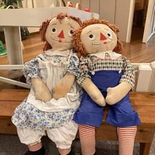 Raggedy Ann and Raggedy Andy cloth dolls shown together.