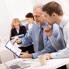 An experienced mentor advising several younger professionals.