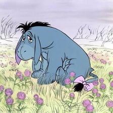 Eeyore beside or eating thistle plants in a Winnie-the-Pooh illustration