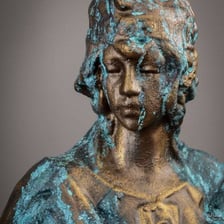 Green patina covering the surface of an aged copper statue