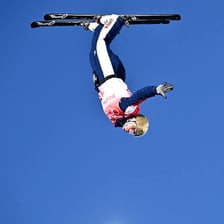 A skier in midair performing a trick above a snowy slope.