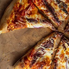 A pizza topped with visible anchovy fillets.