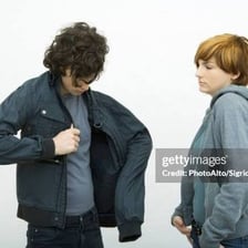 A person taking off a jacket while changing clothes