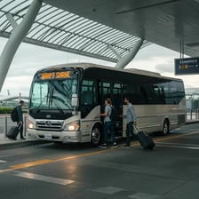 A shuttle bus waiting outside an airport terminal.