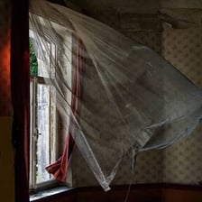 A curtain puffed outward by a strong breeze.