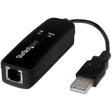 Several small USB dongles and hardware adapters beside a computer.