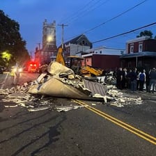 A damaged street being inspected and cleaned after a major storm.