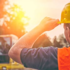 A builder in safety gear at a construction site.